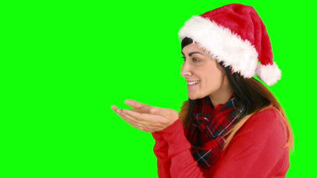 Festliche-brunette-in-Weihnachtsmütze-Blasen-über-die-Hände