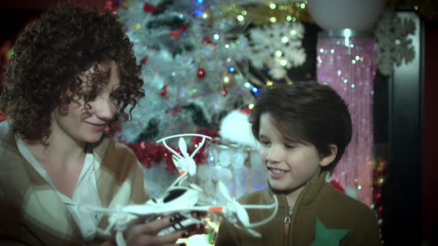 4-k-Navidad-y-año-nuevo-vacaciones-niño-mostrando-su-Drone-presente-a-mamá