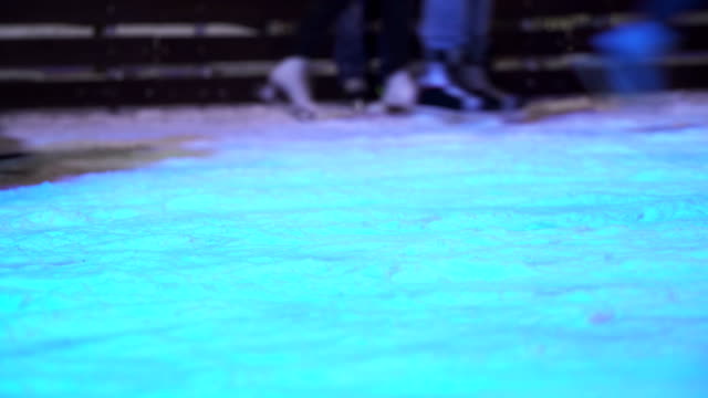 Konzept-Nahaufnahme-Wintersport.-Menge-bei-Nacht-City-Skating-Rink-Pedestal-\"und\"-Unschärfe