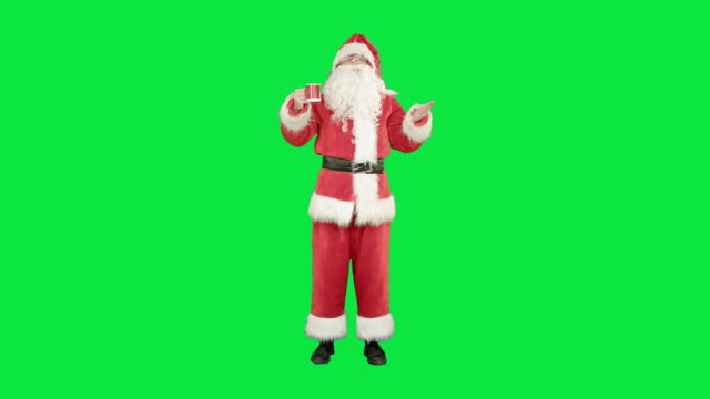 Weihnachtsmann-trinkt-heißen-Tee-oder-Kaffee-und-wünscht-Frohe-Weihnachten-auf-einem-grünen-Bildschirm,-Chroma-Key