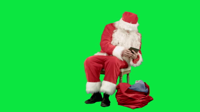Weihnachtsmann-auf-dem-Tablet-im-neuen-Jahr-auf-einem-grünen-Bildschirm-Chrome-Schlüssel