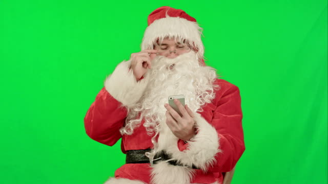 Santa-Claus-Lee-y-envía-mensajes-de-texto-desde-su-teléfono-celular-en-una-pantalla-verde-Chrome-Key