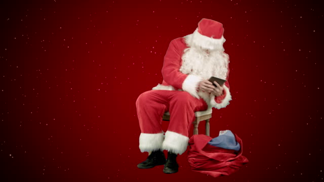 Santa-Claus-en-la-tableta-en-el-año-nuevo-sobre-fondo-rojo-con-nieve