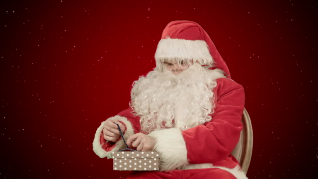 Santa-Claus:-regalos-alegres-sobre-fondo-rojo-con-nieve