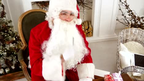 Weihnachtsmann,-der-das-Schreiben-beendet-und-seinen-Brief-an-ein-Kind-prüft
