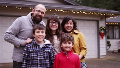 Porträt-von-einem-gemischten-Rennen-Familie-vor-ihrem-Haus-mit-Weihnachtsbeleuchtung