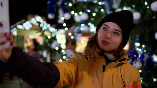Junge-Frau,-die-Aufnahme-von-Fotos-mit-Handy-auf-Weihnachtsmarkt