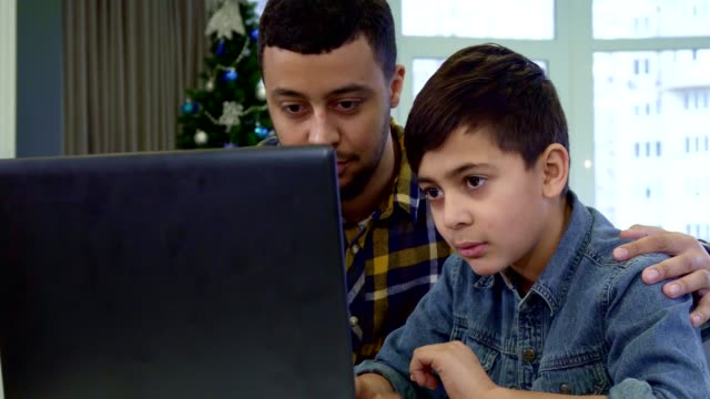 Father-and-son-waving-at-the-laptop