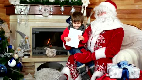 niño-en-el-regazo-de-Santa-Claus-contando-sus-deseos-de-Navidad,-niño-visita-la-residencia-de-invierno-de-San-nicolas
