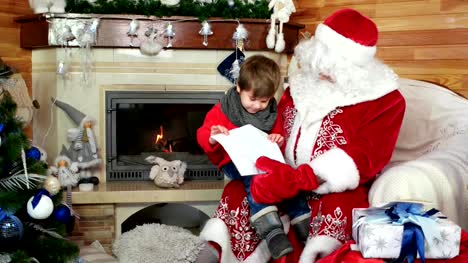 kleiner-Junge-öffnen-seine-Weihnachtsbrief,-Kind-sitzt-auf-Santas-Schoß,-Kind-besuchen-Saint-Nicolas-Residenz