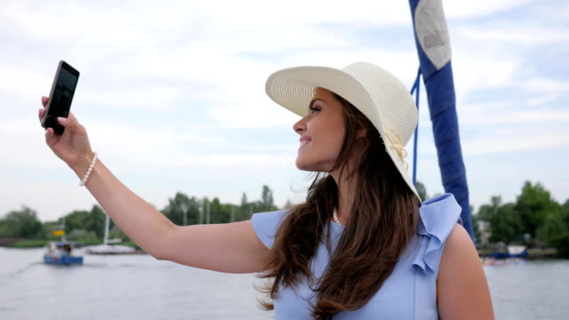 nice-girl-make-selfie-on-yacht,-android-in-hand-women,-holiday-pictures,-woman-do-pictures-on-your-mobile-phone-in-open-air