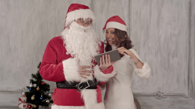 Lachenden-Santa-und-schöne-Frau-nutzen-tablet