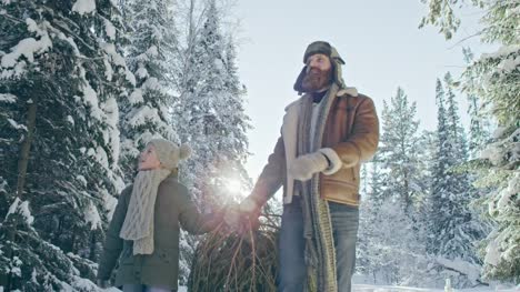 Vater-und-Sohn-tragen-Weihnachtsbaum-aus-Wald