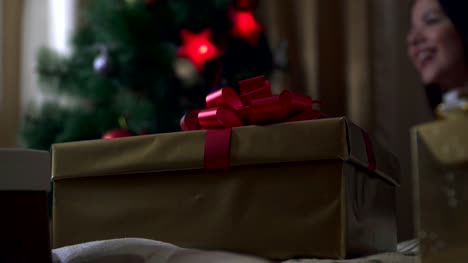 Silvester-Geschenke-stehen-im-Vordergrund,-und-das-Mädchen-schmückt-den-Weihnachtsbaum-auf-dem-Rücken.