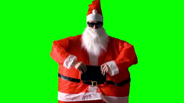 Santa-Claus-reveals-a-new-cool-tablet-PC-on-a-green-background.
