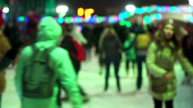 Concept-winter-sport.-Crowd-at-night-skating-city-Rink.-Large-crowd-of-happy-people-having-fun-skating.-Falling-Snow.-Christmas-Days-Blur.-Sport-and-good-mood-Conception.-Families-and-happy-couple-skating