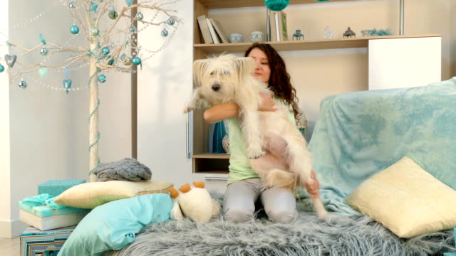 Das-Mädchen-umarmt-und-spielt-mit-dem-Hund-auf-dem-Bett