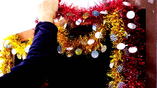 4K-Hände-einer-Person-hängen-Weihnachtsdekoration-an-der-Wand