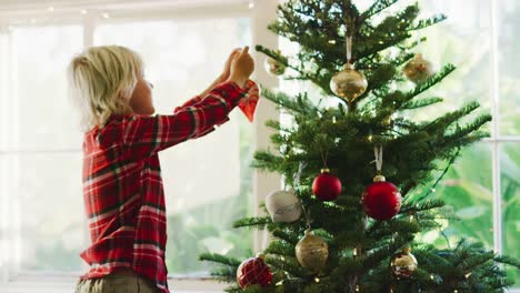 Kleiner-Junge-dekorieren-Weihnachtsbaum