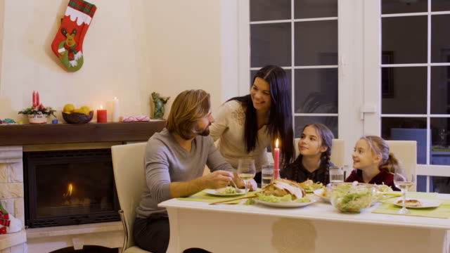 Glückliche-Familie-feiert-Weihnachten-auf-dem-festlich-gedeckten-Tisch