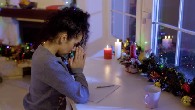 Schönes-Mädchen-betet-vor-dem-Schreiben-einer-Wunschliste-auf-dem-Weihnachtsmarkt