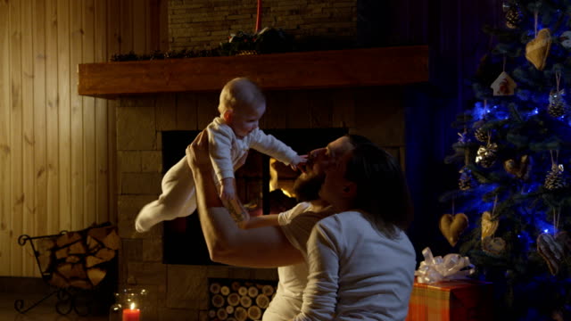 Young-happy-family-with-infant-celebrating-Christmas