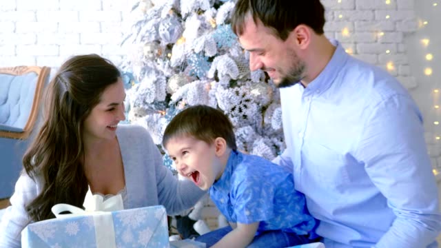 Glückliche-Familie,-Mutter-Vater-Sohn,-stapeln-sich-Kartons-mit-Geschenken.-Weihnachten-Hintergrund.