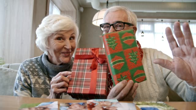 Älteres-Ehepaar-posiert-mit-Weihnachtsgeschenke