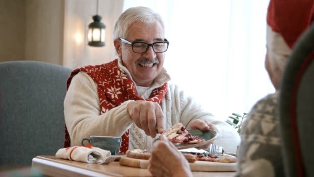 Senior-woman-Umhüllung-Weihnachts-Torte-für-Frau-beim-Abendessen-im-Restaurant