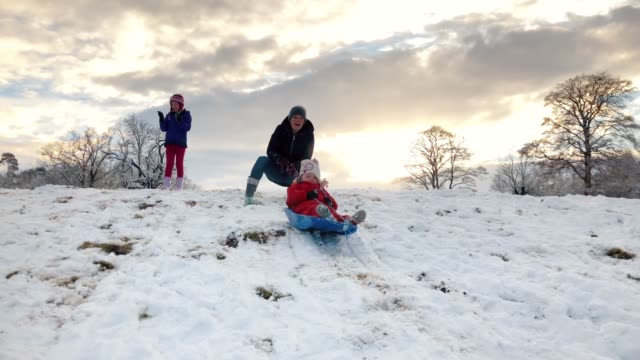 Toddler-girl-going-down-a-sledge-on-a-snowy-hill