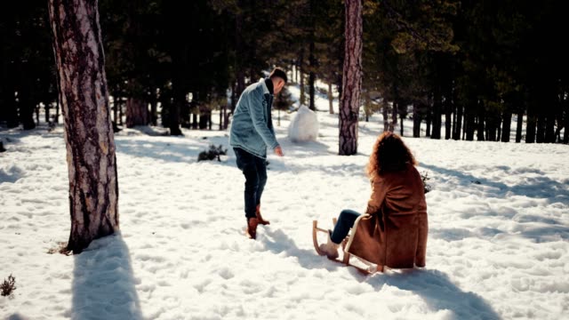 Novio-novia-tirando-trineos-en-nieve-Parque-forestal