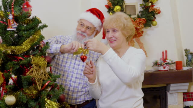 Glückliche-alte-Paar-machen-Dekoration-des-Weihnachtsbaumes