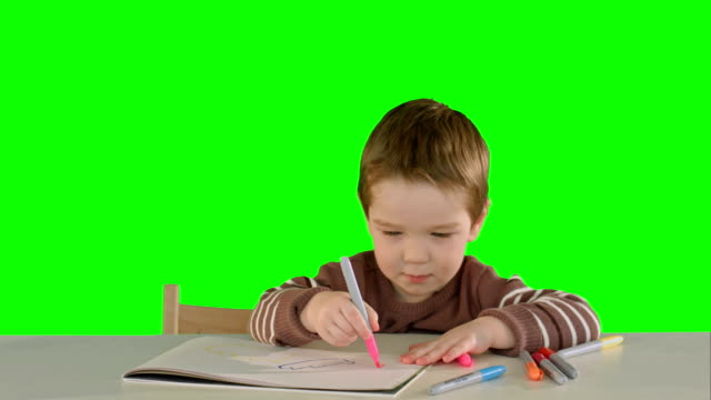 Sohn-Zeichnung-am-Tisch-zu-Hause-auf-einem-grünen-Bildschirm