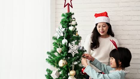 Mom-and-daughter-decorate-the-Christmas-tree
