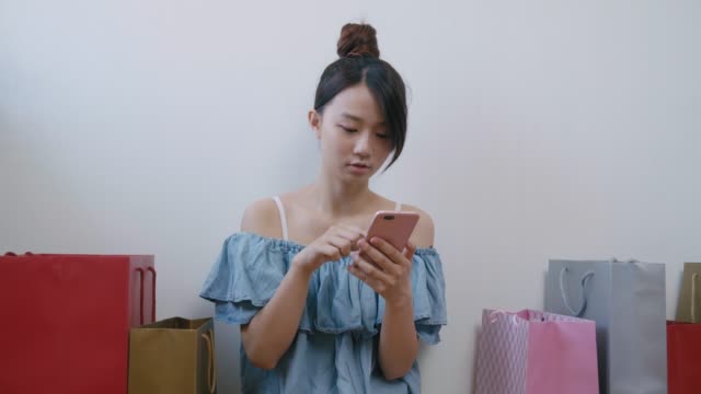 Mujer-usando-teléfono-celular,-mientras-que-las-compras