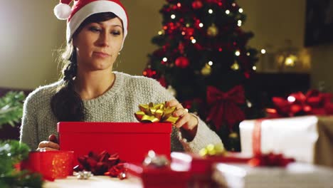 la-mano-de-una-persona-decora-el-árbol-de-Navidad-con-las-bolas-de-oro-y-rojos.-concepto-de-esperar-para-Navidad-y-año-nuevo.