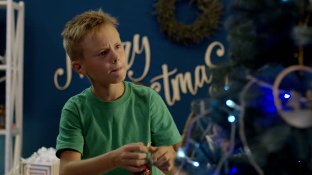 Boy-decorating-Christmas-tree-at-home