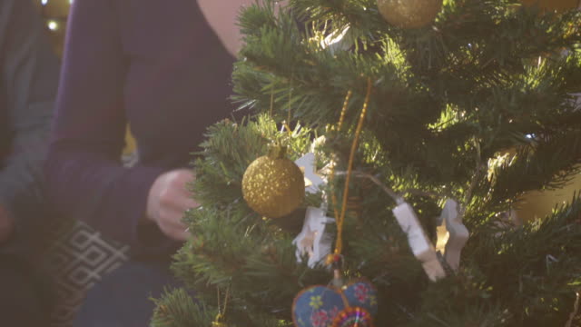Mujer-joven-decorar-un-árbol-de-navidad