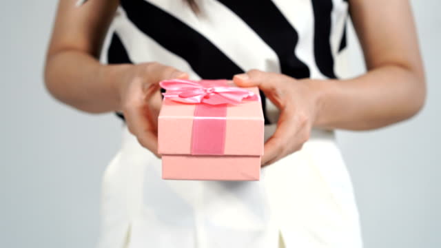 Frau-mit-einem-rosa-Geschenkbox-in-einer-Geste-des-Gebens.