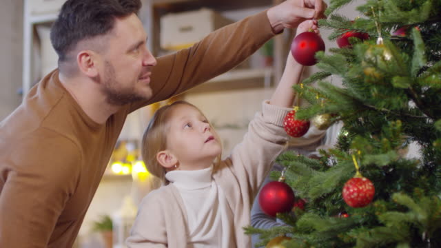 Padre-e-hija-pequeña-decoración-árbol-de-Navidad
