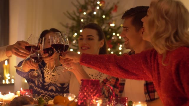 Glückliche-Freunde-trinken-Rotwein-zu-Weihnachten