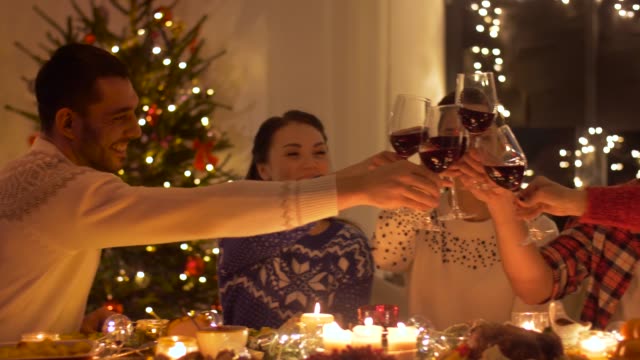 happy-friends-drinking-red-wine-at-christmas