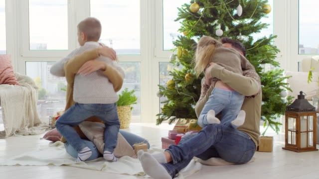 Niños-abrazando-a-los-padres-en-la-mañana-de-Navidad
