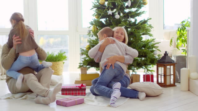 Kinder-umarmen-Großeltern-am-Weihnachtsmorgen
