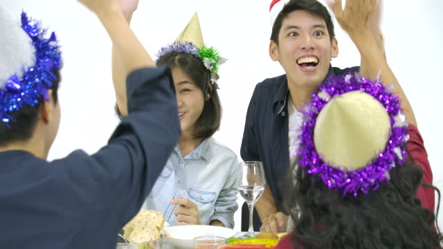 Gruppe-von-Asiaten-am-Tisch-versammeln-und-Weihnachten-zusammen-mit-leckeren-Essen-an-Silvester-Party-zu-feiern.-Menschen-mit-Urlaub-und-Feier-Konzept.