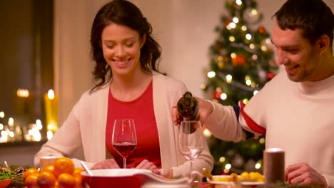 glückliches-Paar-trinken-Rotwein-am-Weihnachtsessen