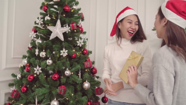 Gruppe-von-fröhlich-glücklich-junge-asiatische-Frauen-Weihnachten-Geschenke-miteinander-in-ihrem-Wohnzimmer-zu-Hause-in-Christmas-Festival.-Lifestyle-Frauen-feiern-Weihnachten-und-Neujahr-Konzept.