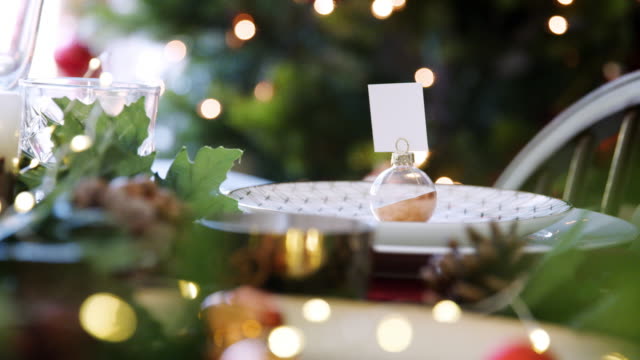 Christbaumkugel-Name-Karteninhaber-auf-einem-Esstisch-dekoriert-für-Weihnachtsessen,-Rack-Fokus-Schuss-hautnah