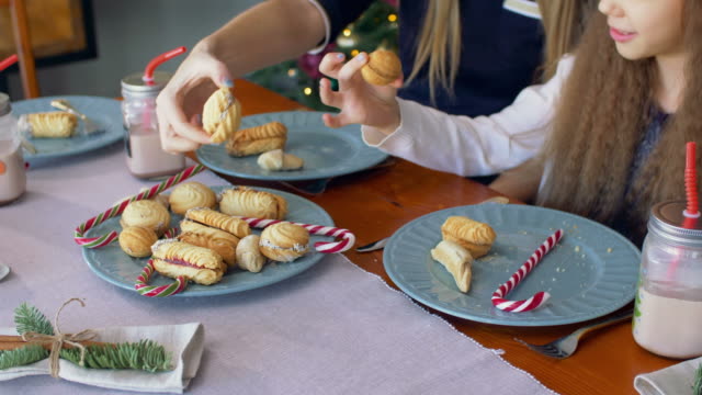 Hands-taking-christmas-cookies-and-candy-from-plate