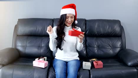 happy-woman-with-Christmas-gift-in-the-living-room